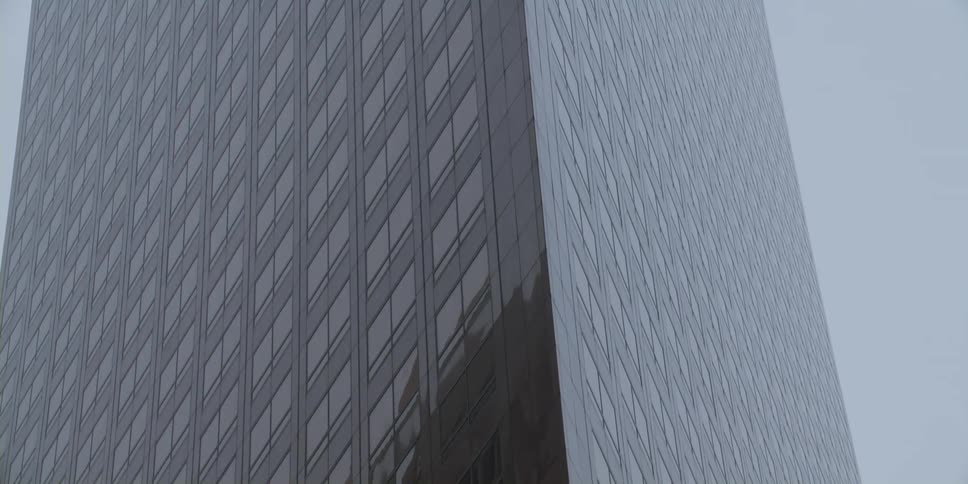 Tall building covered in glass reflection another building