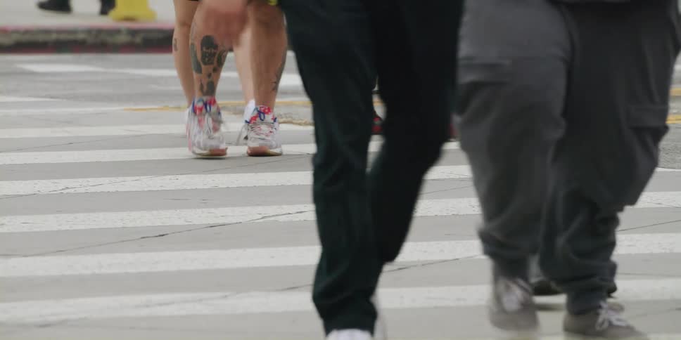 A crowd of people are walking on a street in a city
