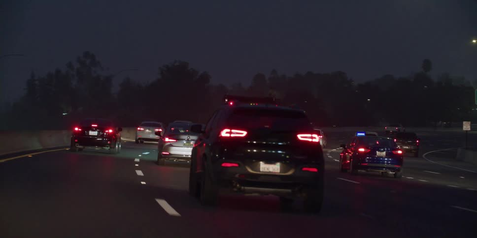 Vehicles brake and go in heavy traffic on a highway at night