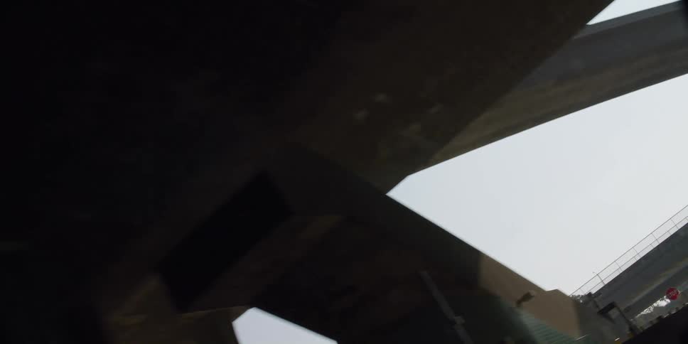 Cars are driving on an overpass in a city