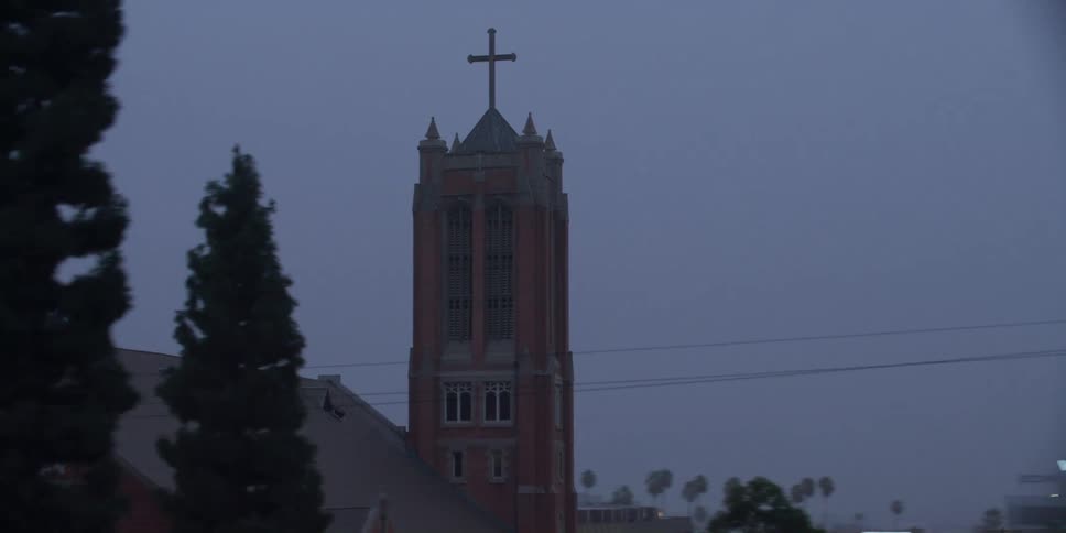 A cross tops a tower at a church near downtown