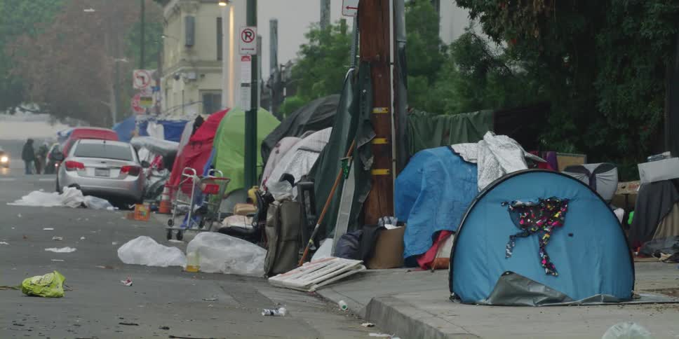 Tents and garbage litter the street at a homeless encampment downtown