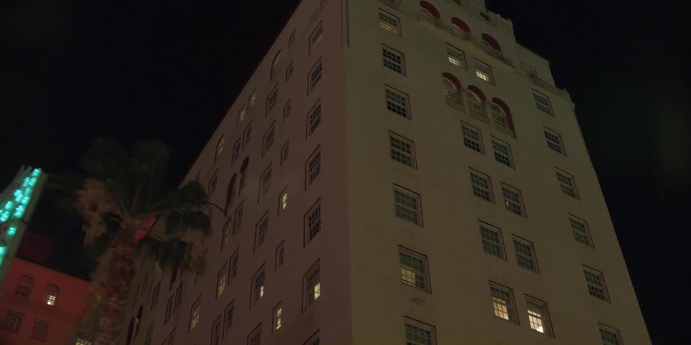 Exterior view of hotel building with singboard at night in the city