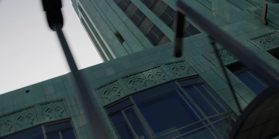 Looking up at a tall building while passing by in a vehicle in the evening
