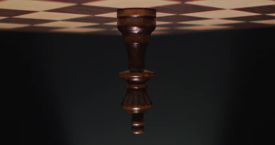 A single chess piece is on the game board and the view is upside down