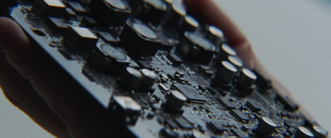 Someone is holding an electronic component in their hand