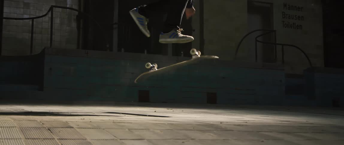 A man does a kick flip on the skateboard
