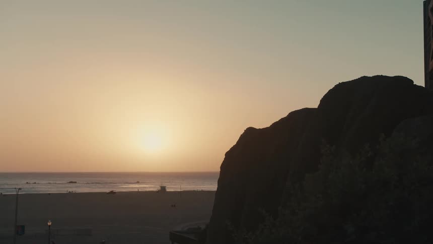 People walk on the beach at sunset