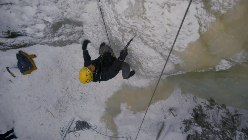 A man is climbing up the cliff