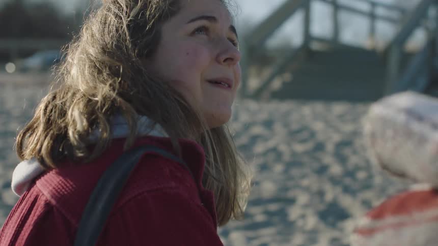 A woman talks on the beach