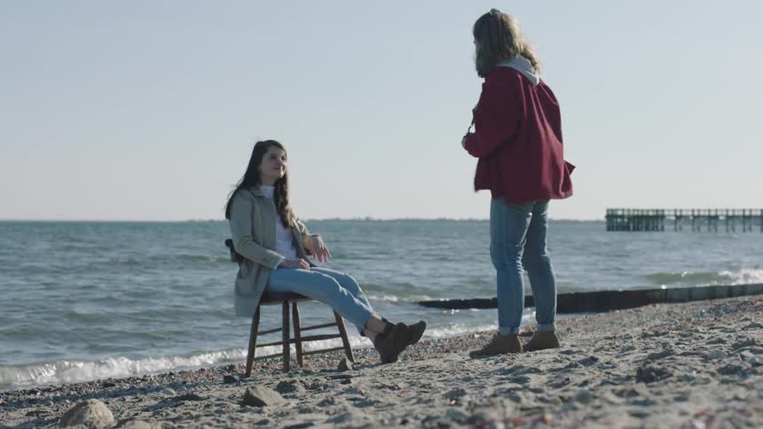A woman is having her photo taken on the beach
