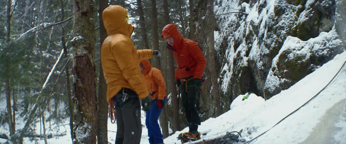 Three people are preparing to rock climb