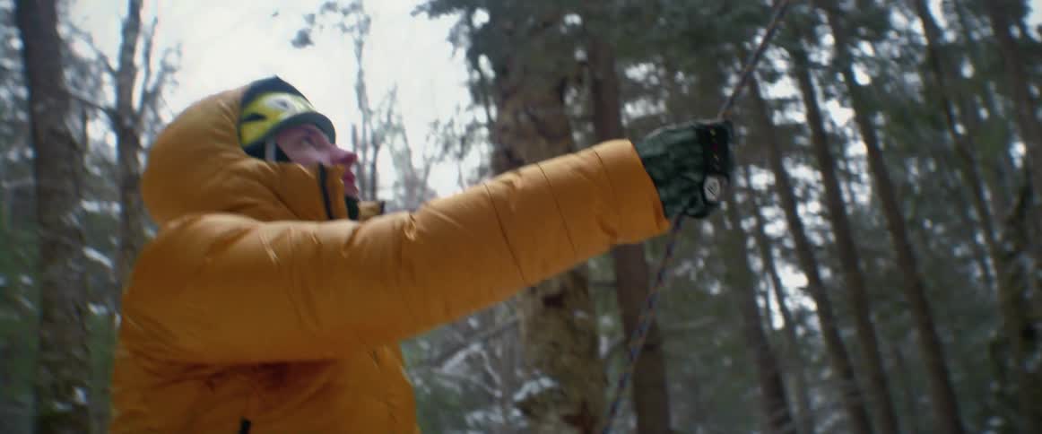 A man is pulling a rope in the woods