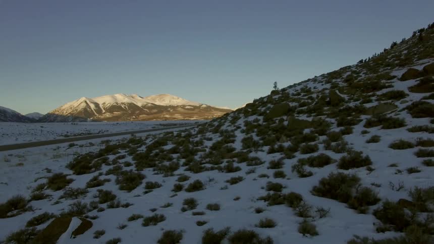 Snow covered mountain peaks set behind snow covered hills