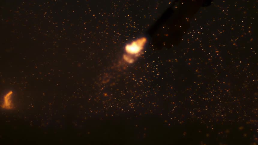 Fireworks going off into a dark sky in slow motion
