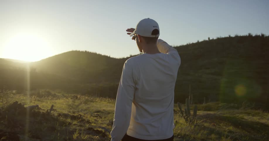 A man looks over as the sun rises