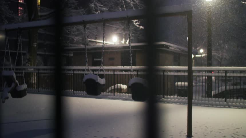The snow is falling on the park