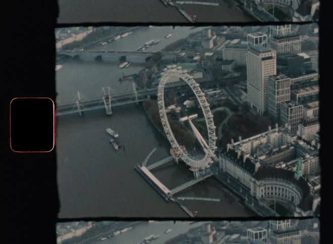 A ferris wheel over a river in a metropolis during the day