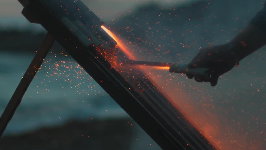 Sparks fly as a man uses a torch to light fireworks