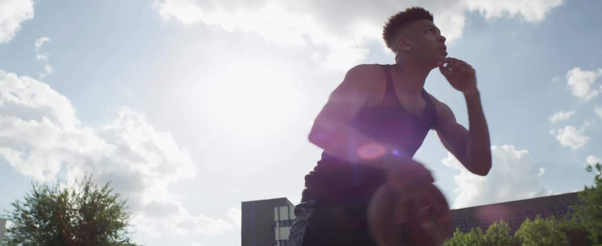 A man is playing basketball outside