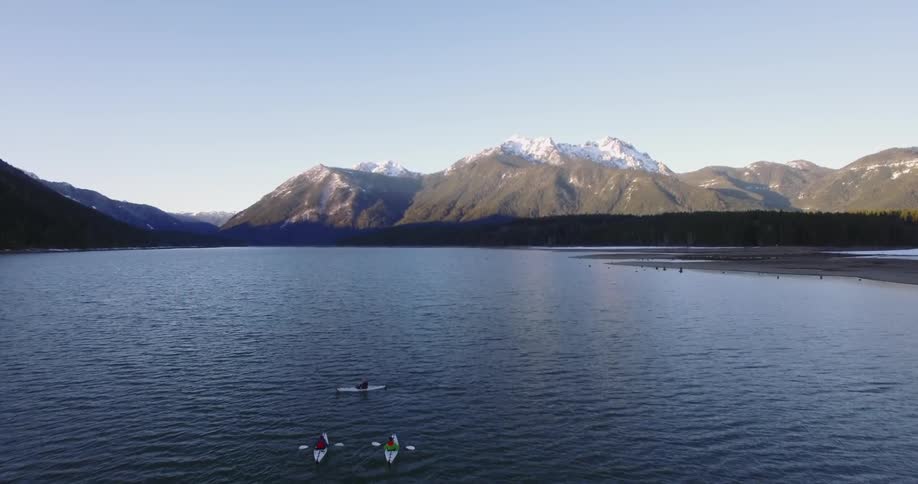 Kayakers paddling along on a mountain lake