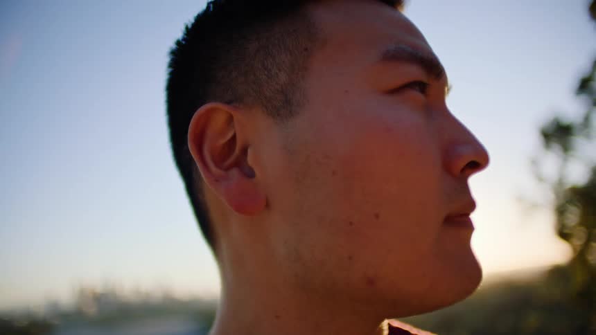 Closeup of asian male outdoors looking off to the side