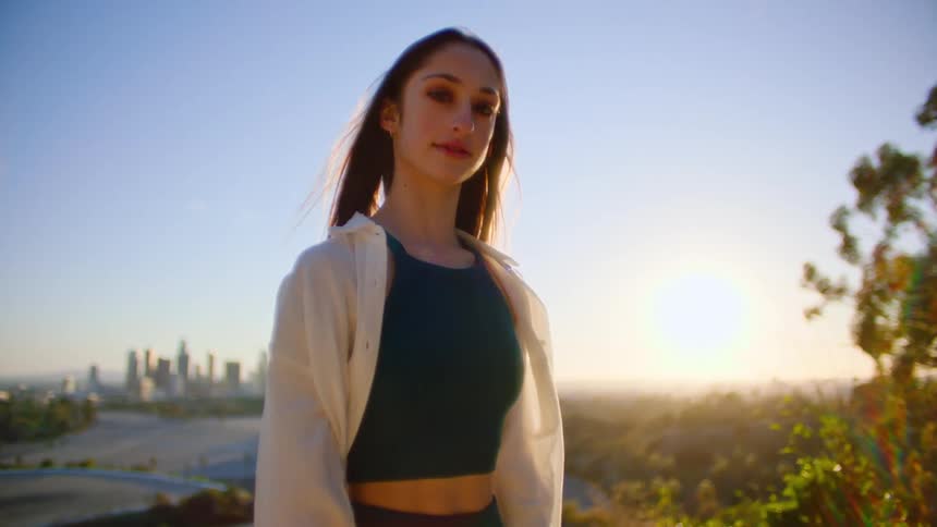 A woman poses at sunrise