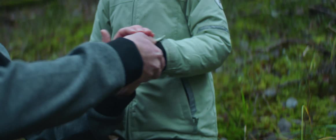 A boy shakes his hand outside