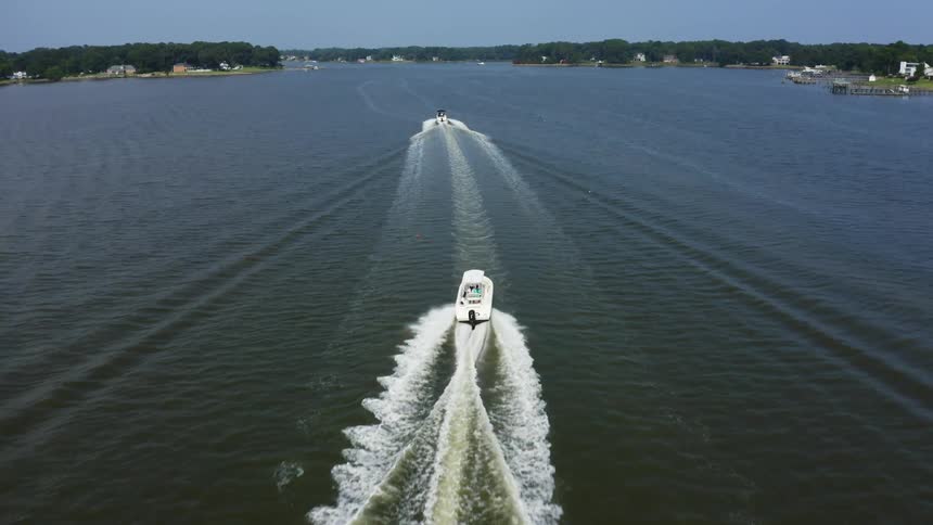 Two boats travel in the water