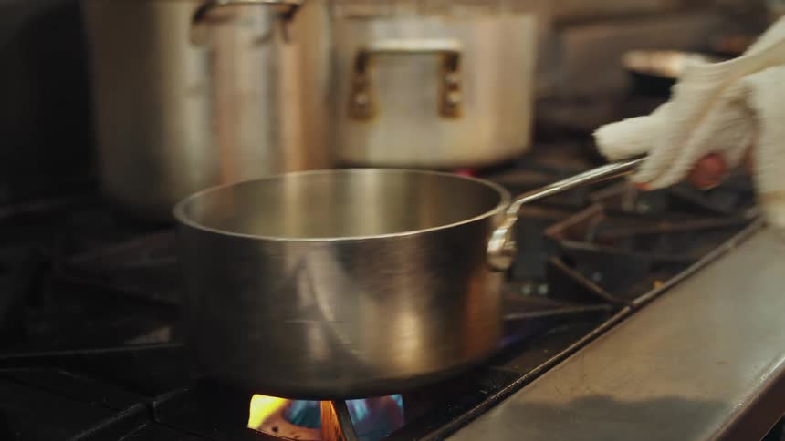 A person cooking on a pot on the stove