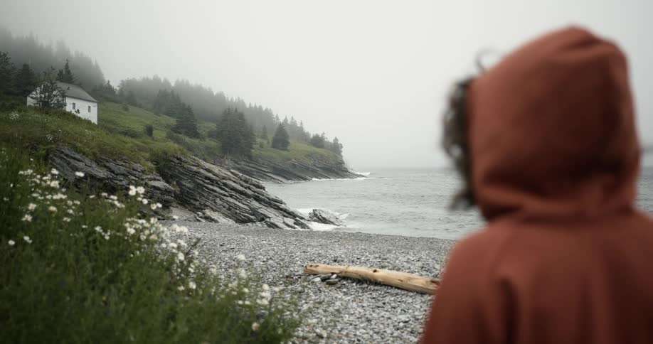 A person standing at the beach on a cloudy day