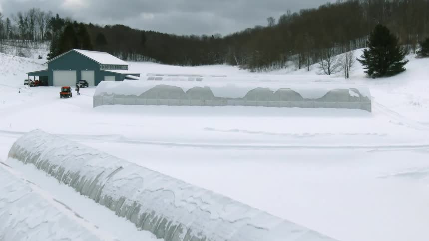 A thick blanket of snow covers silos on a farm