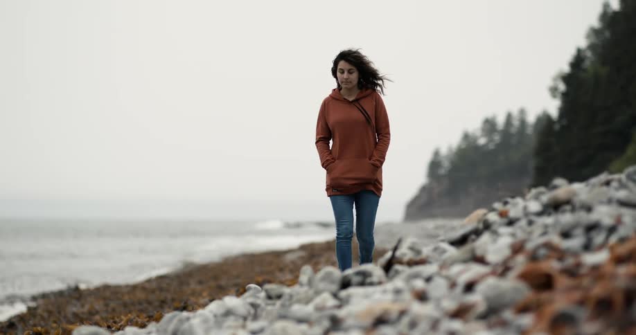 White woman walking alone at the beach