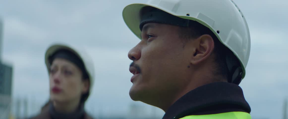 A construction worker talks with a woman