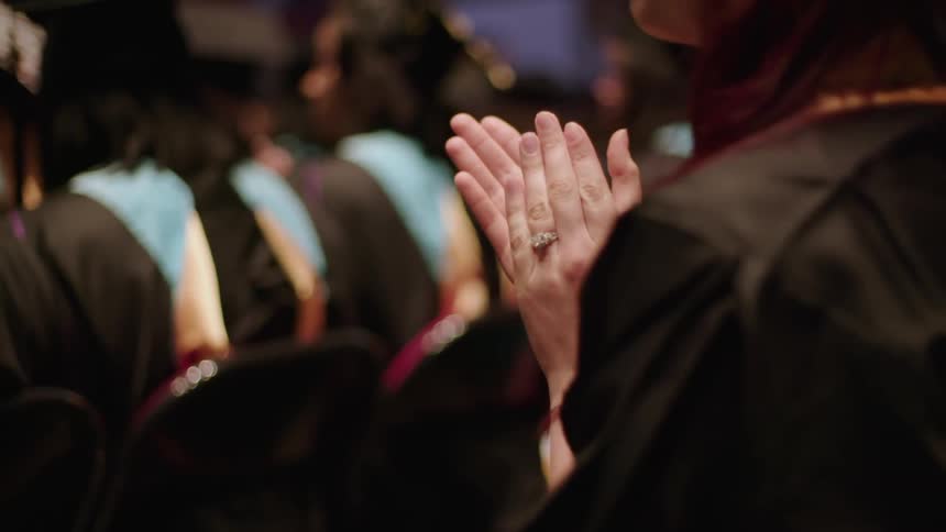 Graduates clap while seated