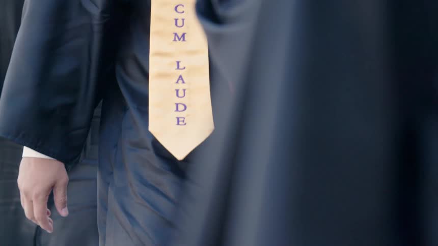 Students walk outside in gowns