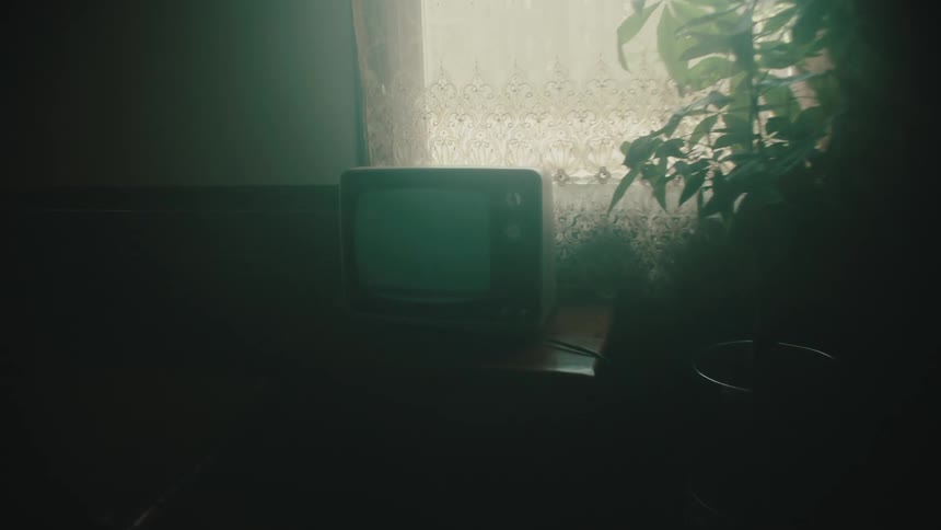 A man walks through his house and turns on a television playing static