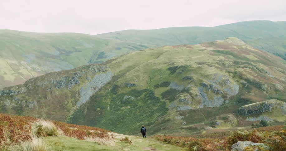 Man with backpack walks downhill