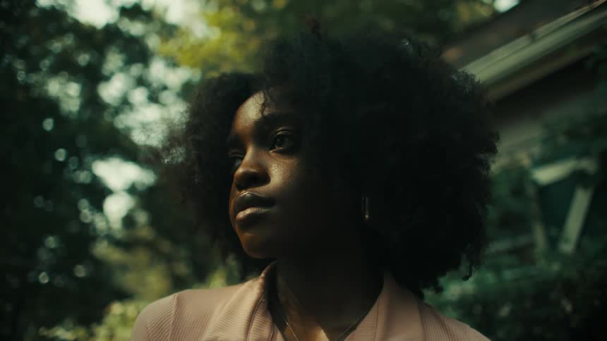 Black woman standing in front of a house posing for the camera