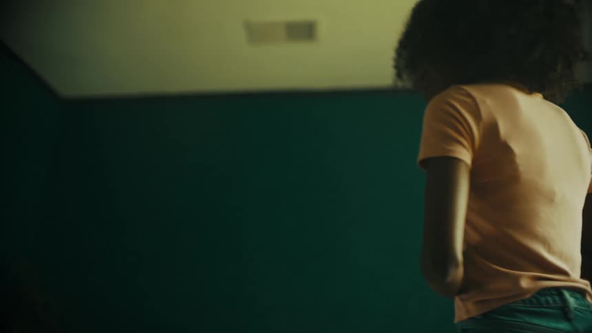 A young woman poses and checks her appearance in front of the window