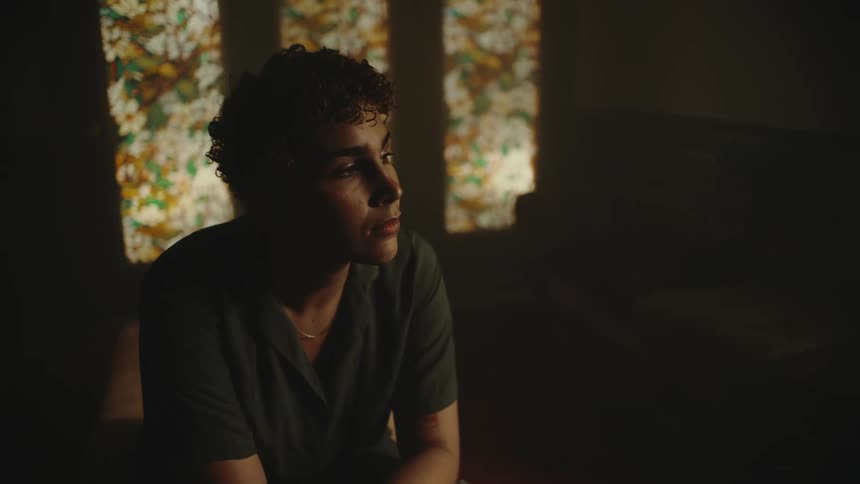 A woman is sitting in a dark room