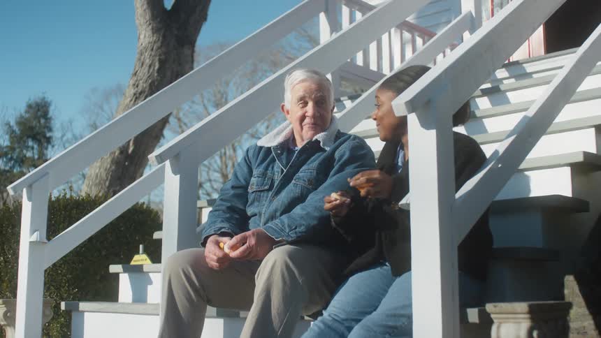 Two people sitting outside talking