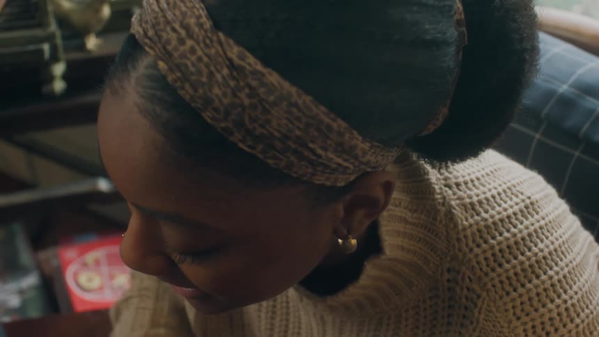 A young black woman in a home talks