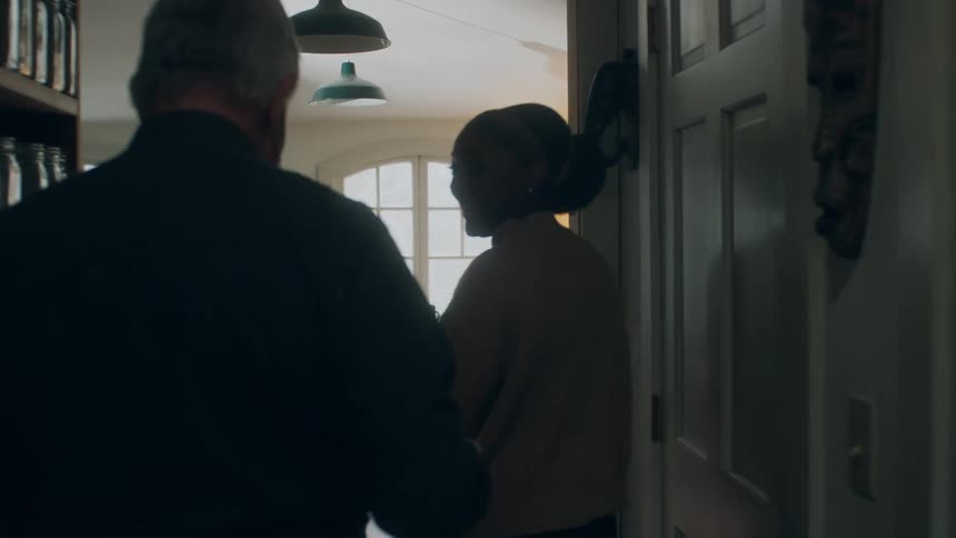 A man and woman walking through a house