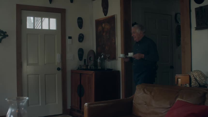 A man brings coffee into the living room