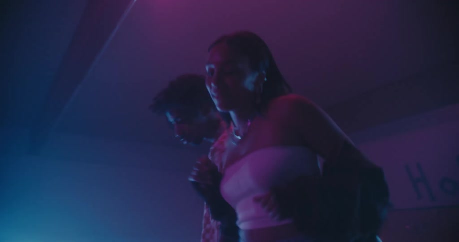 A young man and woman dance down a bowling lane