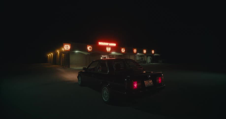 A car is parked outside a building at night