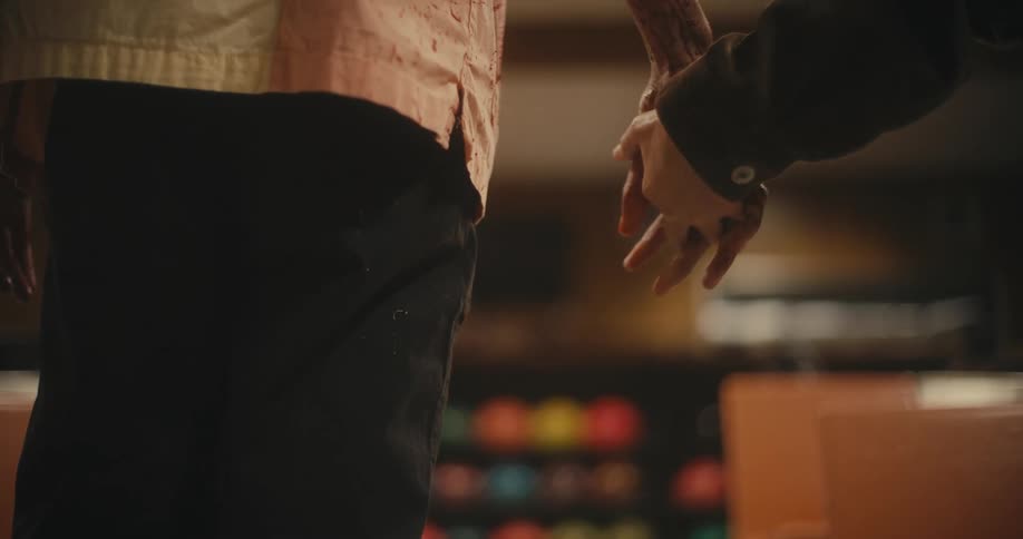 A man drops his bowling ball after his girlfriend grabs his hand to hold