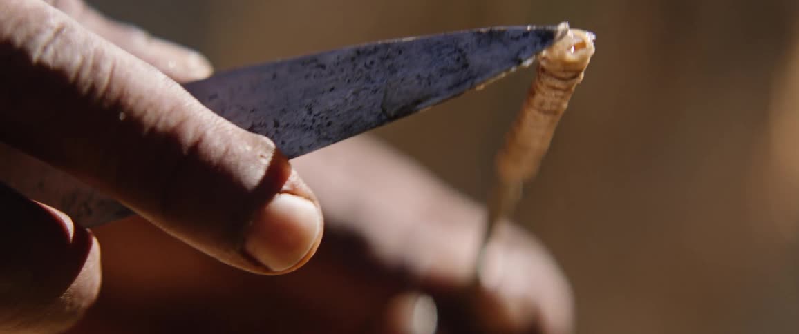 Tribal men making bow and arrows