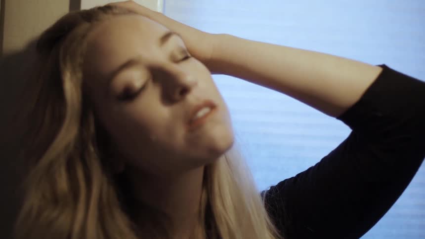 Light shines on a blond woman's face